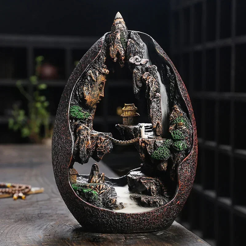 Decorative water fountain with a miniature landscape inside, on a wooden surface.