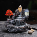 Decorative water fountain with rocks, tree, and lantern on a dark background