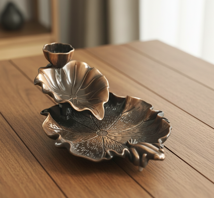 Bronze leaf-shaped candle holder on a wooden surface